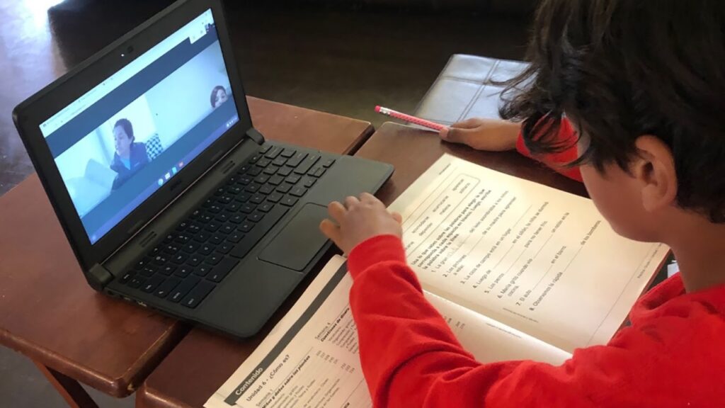 Student participating in online learning with a laptop.